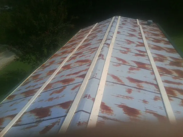 Rusted metal roof panels with new wood purlins before replacement — Storm Damage Roof Repair in Coker by Roofing Brothers