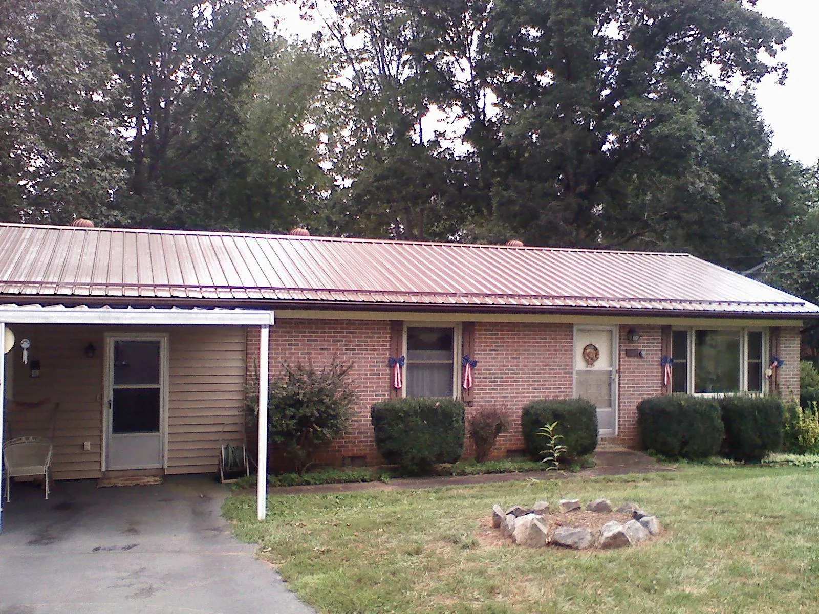 Bronze metal roof and carport on a brick ranch home — Roof Repair work by our crew in Coker